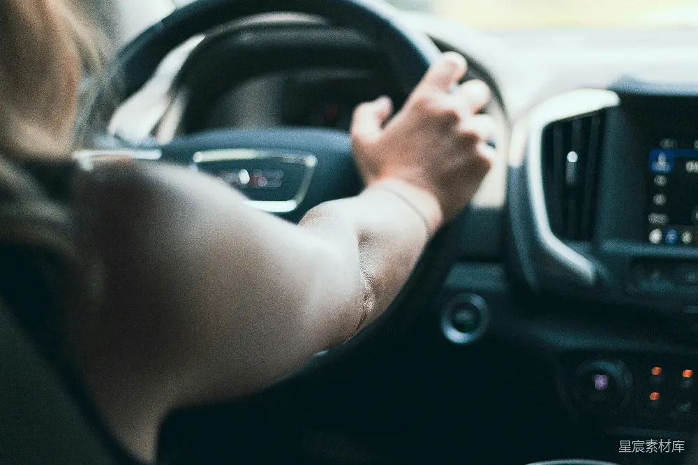 高清摄影 人物 自然 一个女人开着车，手放在方向盘上。