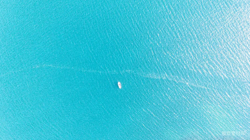 高清摄影  一架飞机俯瞰一艘停泊在碧绿海水中的船只。