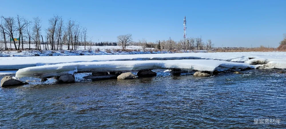 高清摄影  一群被雪覆盖的船只漂浮在河面上。