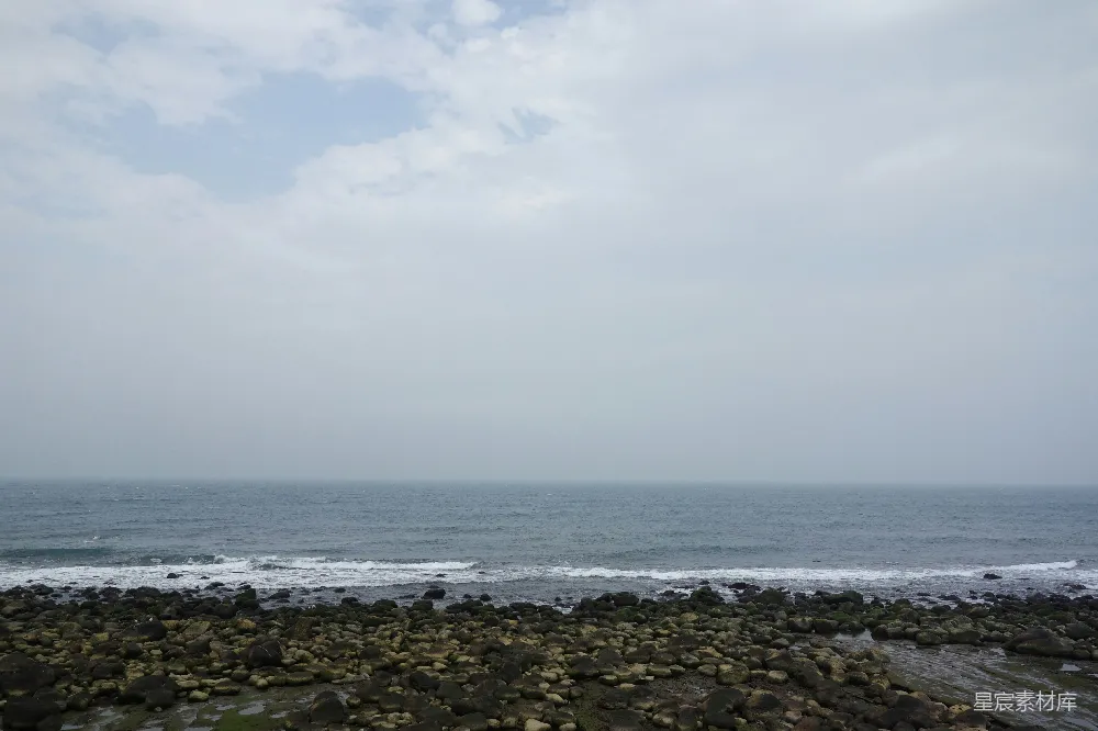 高清摄影  岩石海岸与平静的海洋相接。