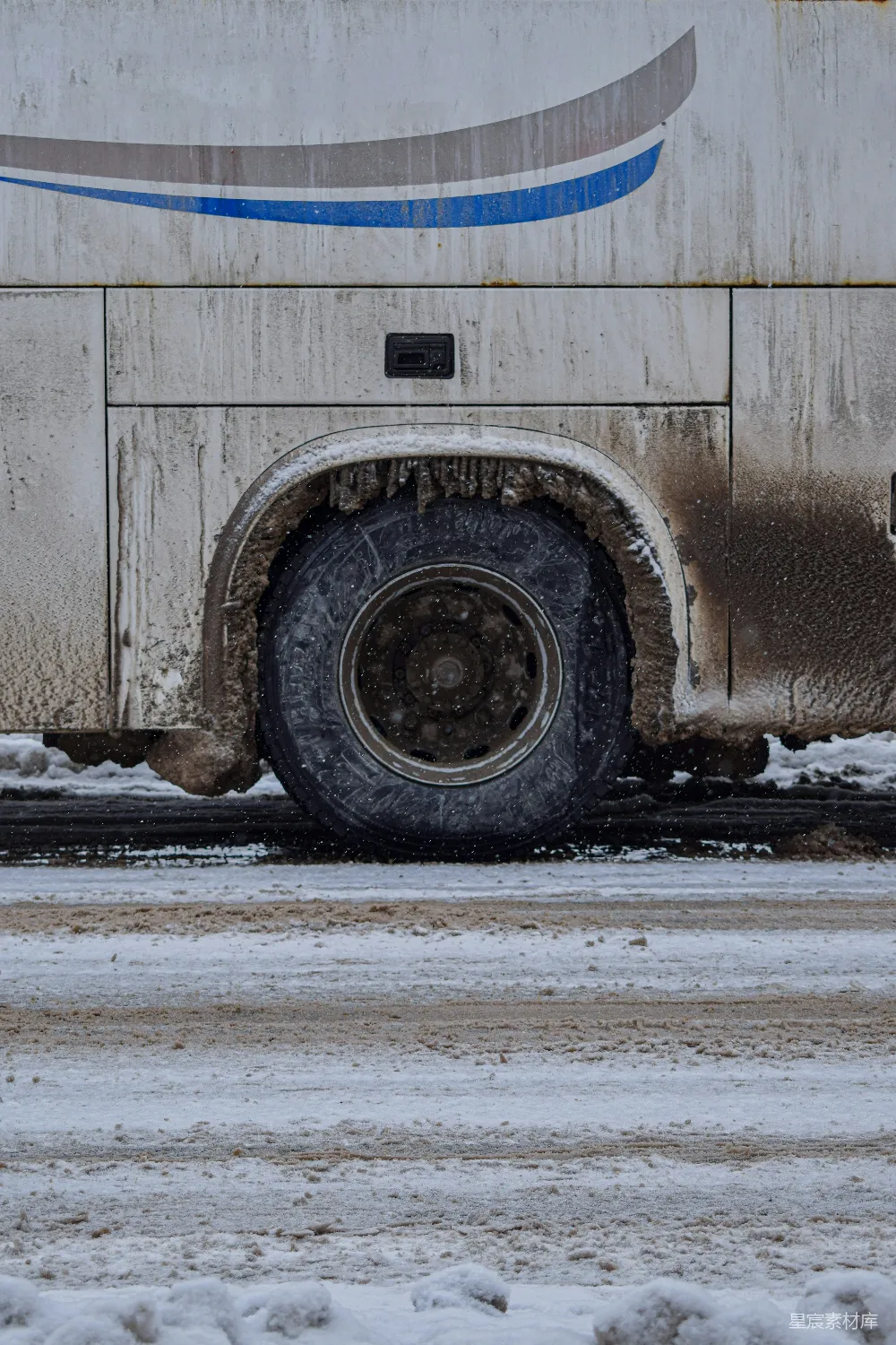 高清摄影  一辆大型白色卡车正在一条覆盖着积雪的道路上行驶