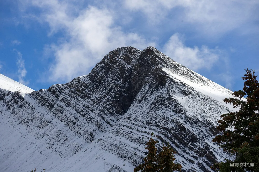 高清摄影  白雪覆盖的山峰在阴云密布的蓝天下。