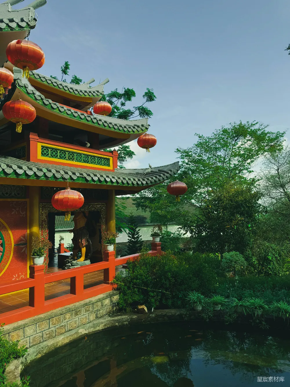 高清摄影  一座色彩斑斓的寺庙坐落在宁静的池塘旁边。