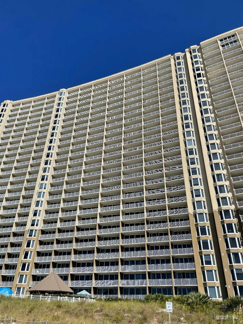 高清摄影  一座非常高的建筑物坐落在海滩的一侧。