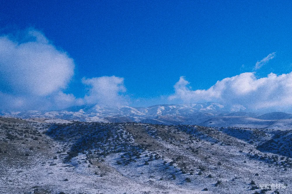 高清摄影  一座覆盖着积雪的山脉在蓝天的映衬下