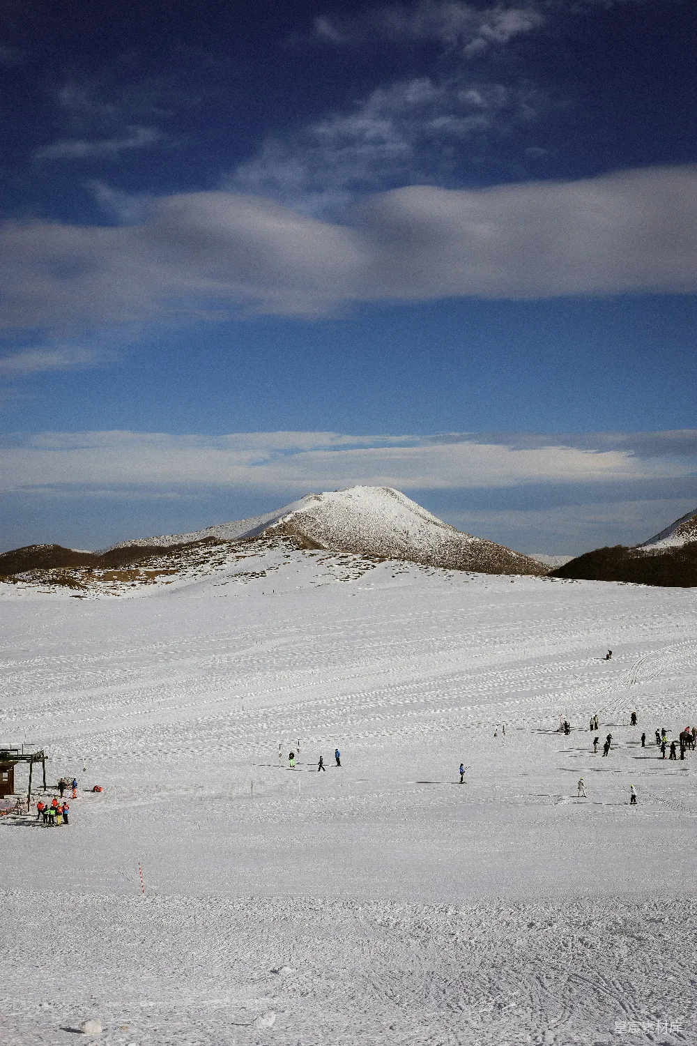 高清摄影  一群人正在穿过一片被雪覆盖的田野。