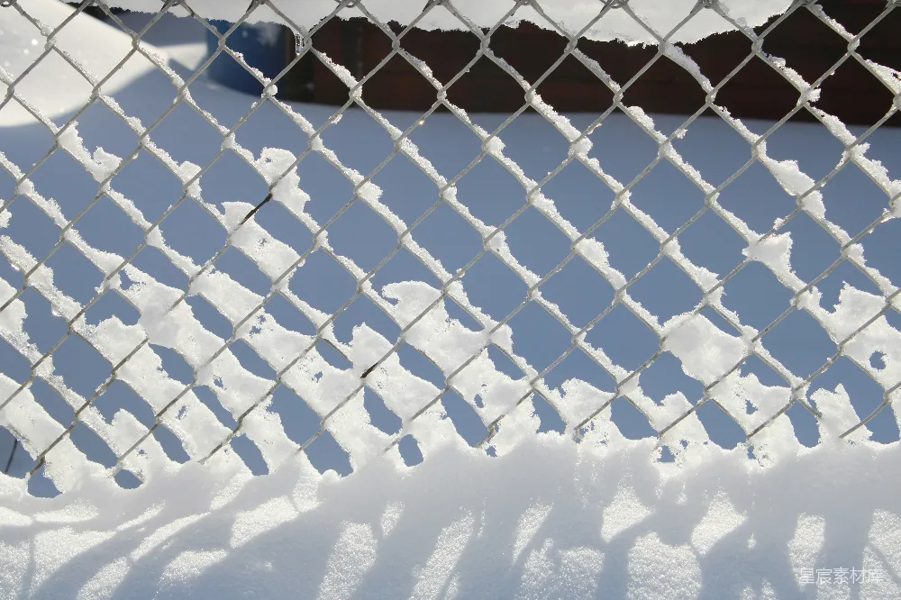 高清摄影  黑色金属栅栏在积雪覆盖的地面上