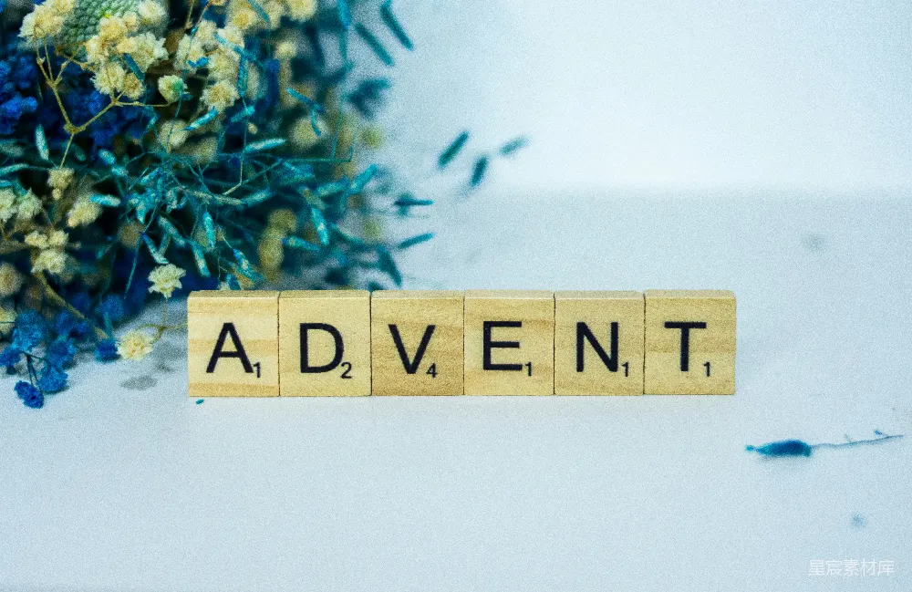 高清摄影  一个写有“adventt”的木块旁边有一束花。