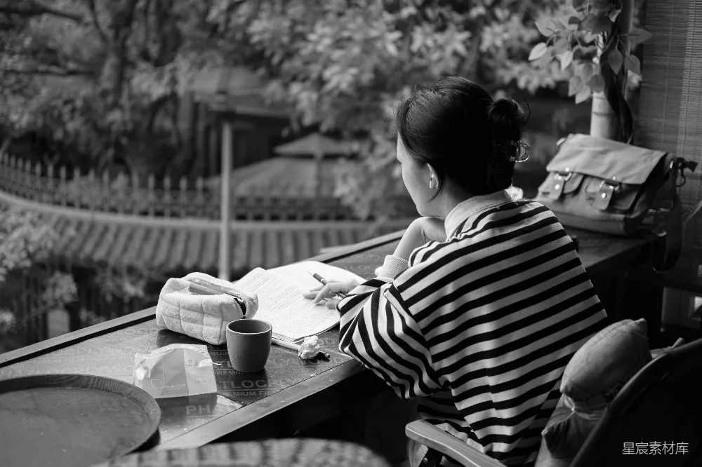 高清摄影  女人在宁静的场景中靠窗写作。