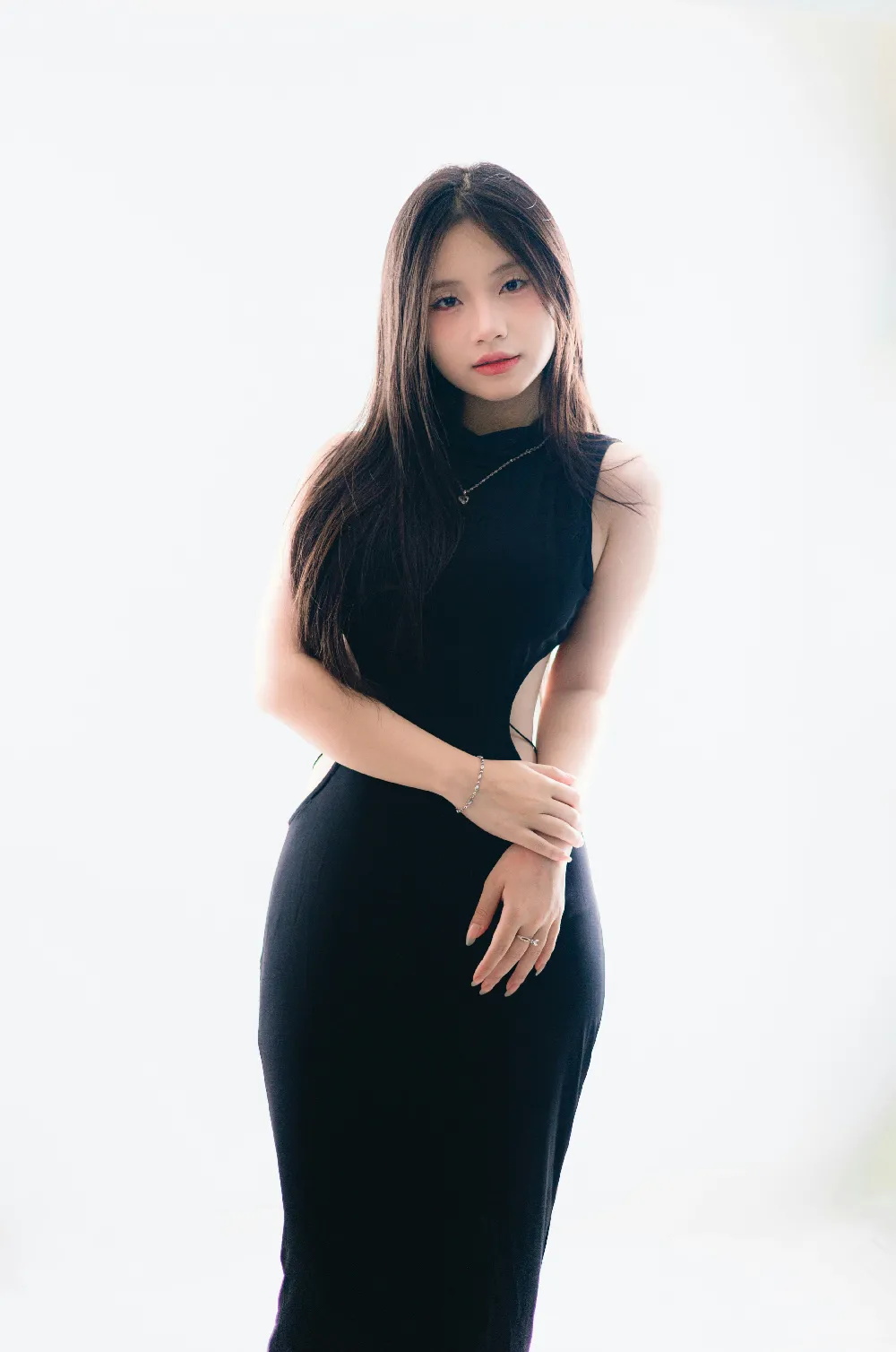 高清摄影  一位年轻女子穿着黑色连衣裙摆姿势。