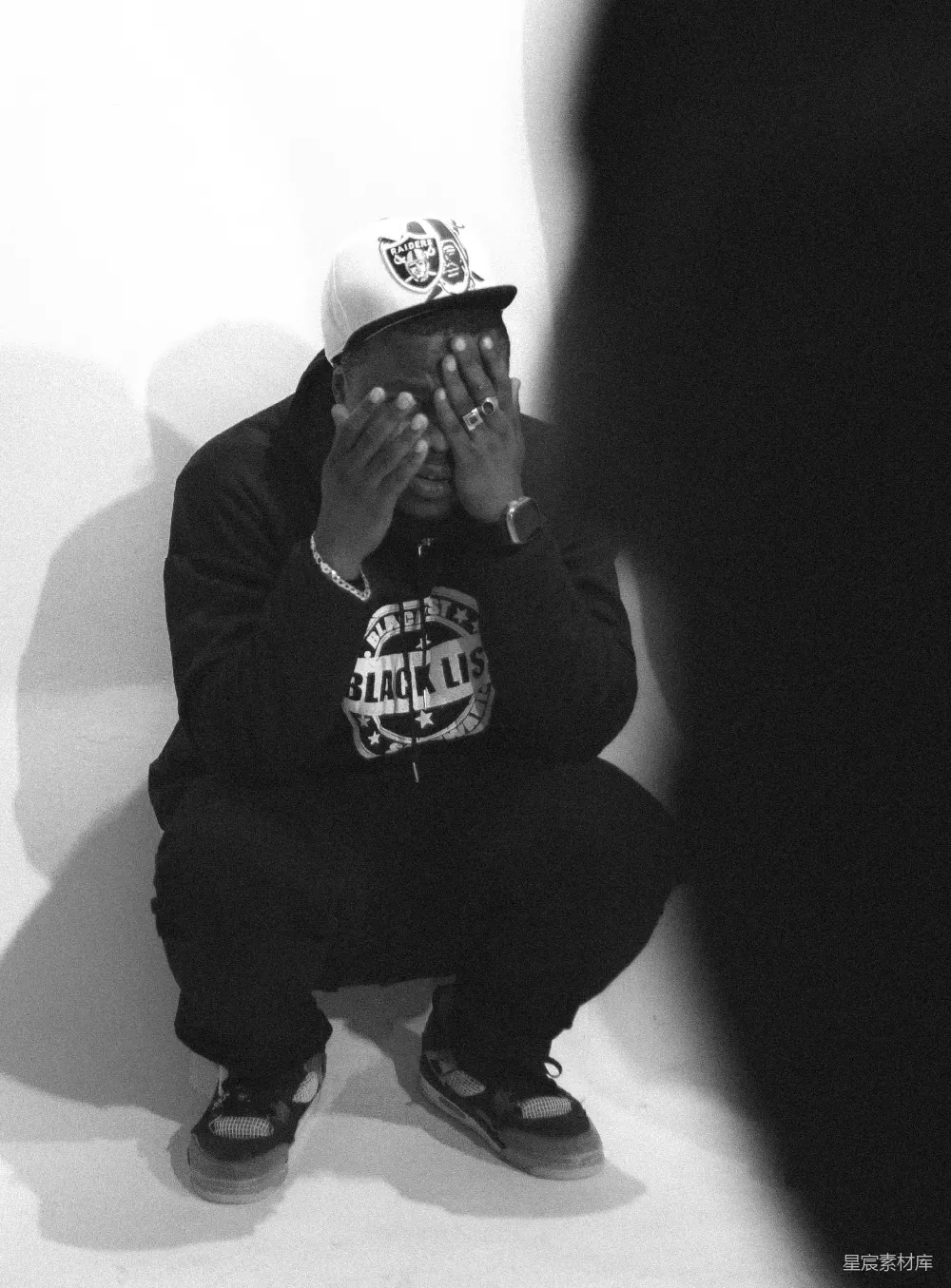 高清摄影  一张黑白照片中，一个男人用手遮住自己的脸。