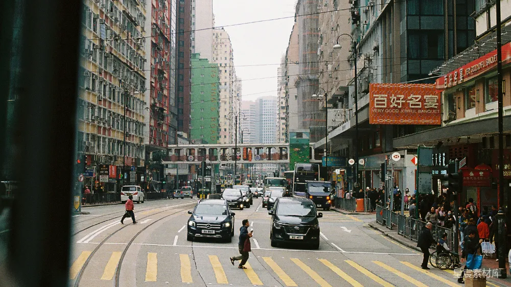 高清摄影  繁忙的香港街道，有车辆和行人。