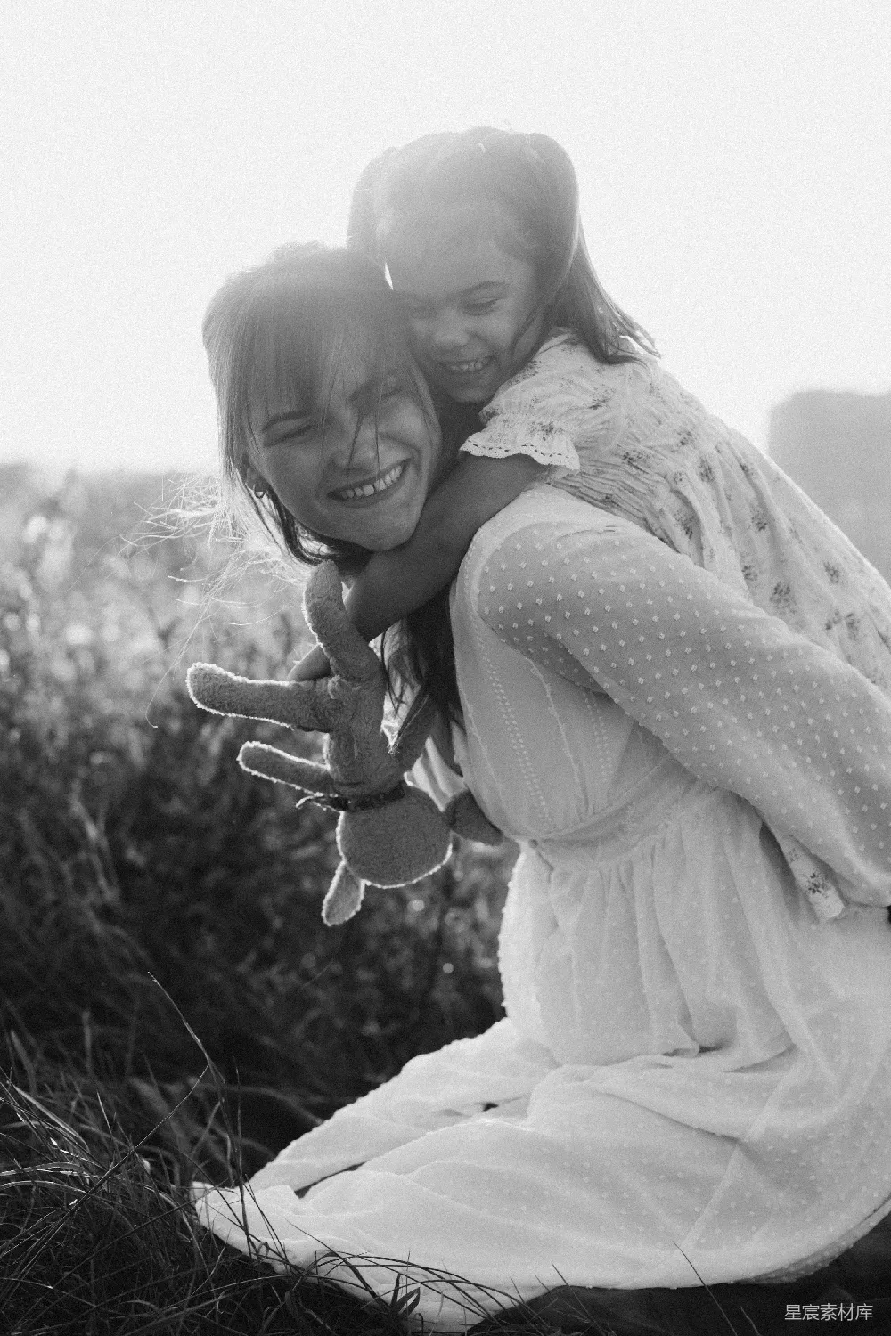 高清摄影  一对年轻的女孩坐在草地上。