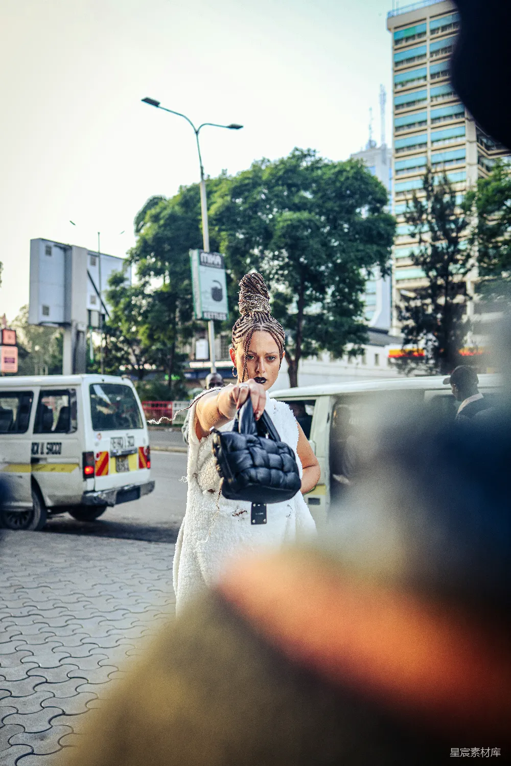 高清摄影  穿着白色连衣裙的女人拿着一只黑色手套