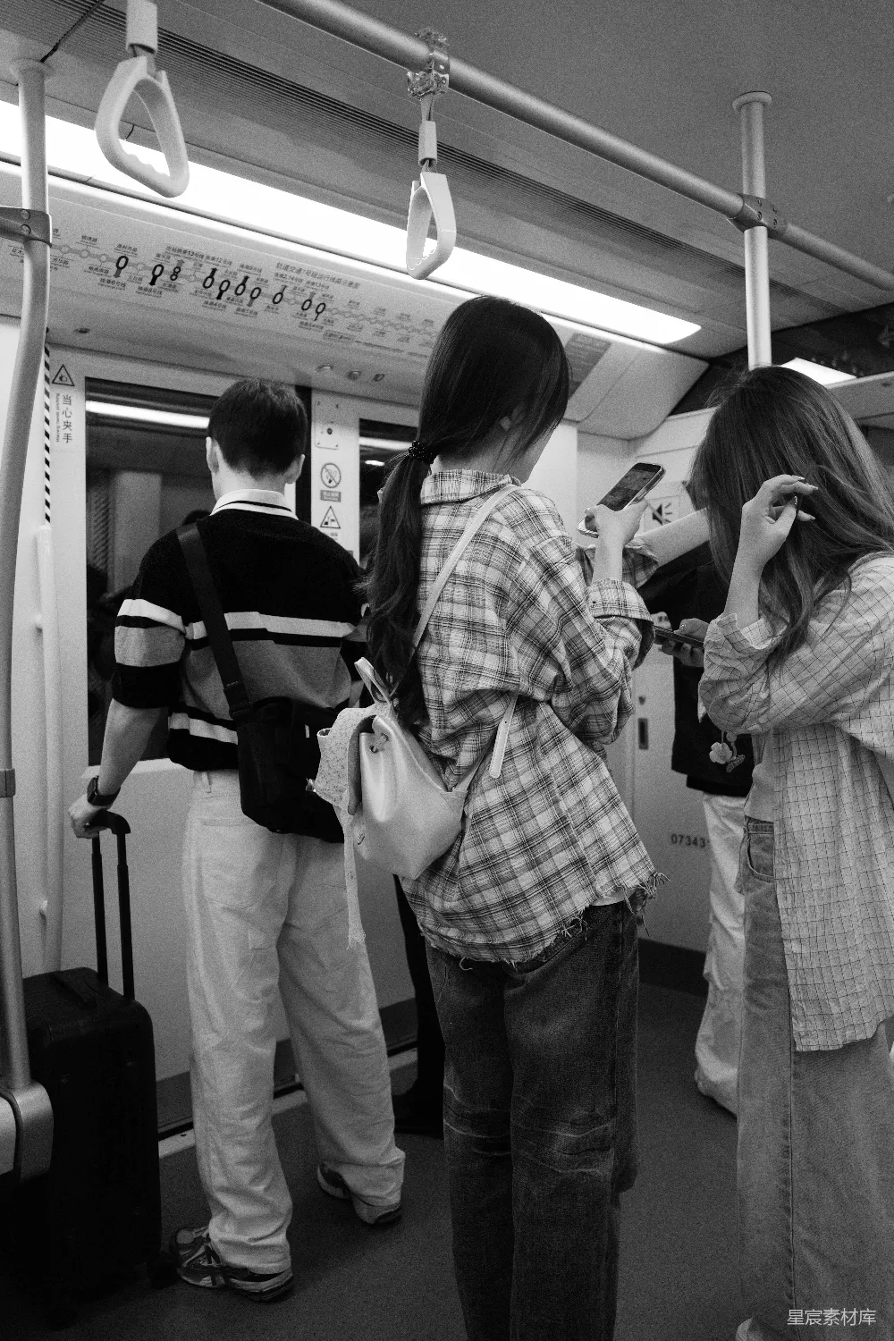 高清摄影  人们乘坐火车，低头看手机和行李。