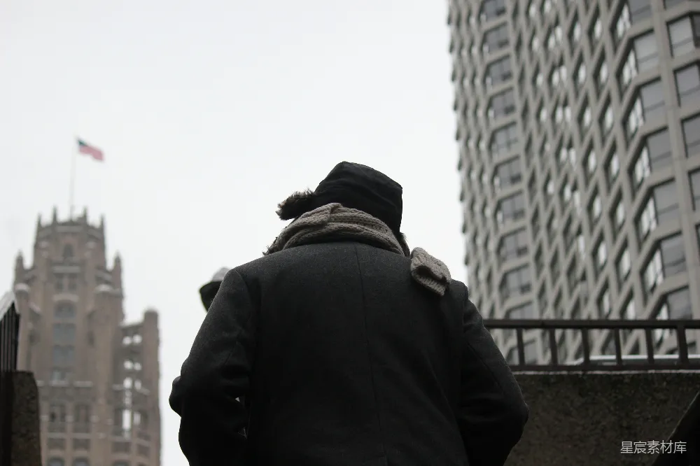 高清摄影  一个人在寒冷的城市里朝一座建筑物走去。