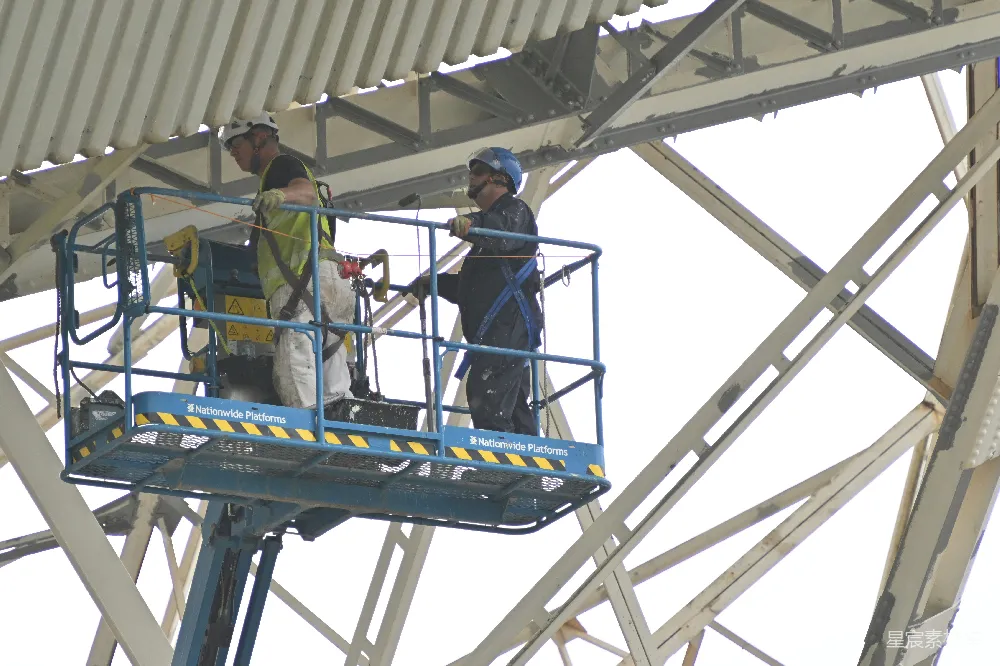 高清摄影  工人使用升降机在建筑物上工作。