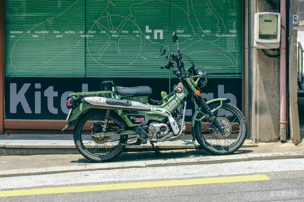 高清摄影  一辆绿色的摩托车停在一家商店前面。