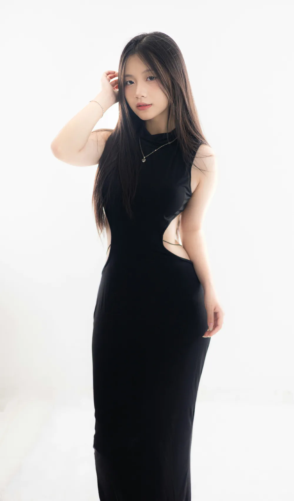 高清摄影  一位女士穿着一件流线型的黑色连衣裙摆姿势。