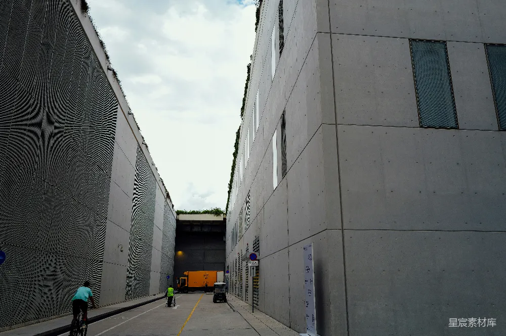 高清摄影  建筑物沿着一条街道排列，街道上有骑自行车的人和行人。