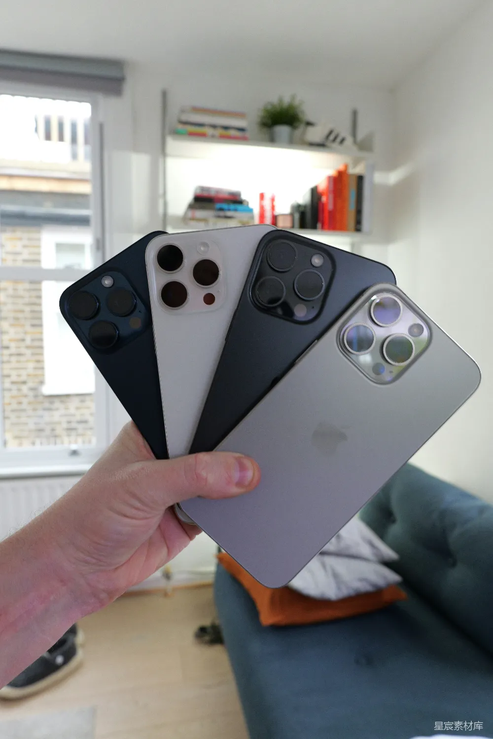 高清摄影  一个人手里拿着四部iPhone手机。