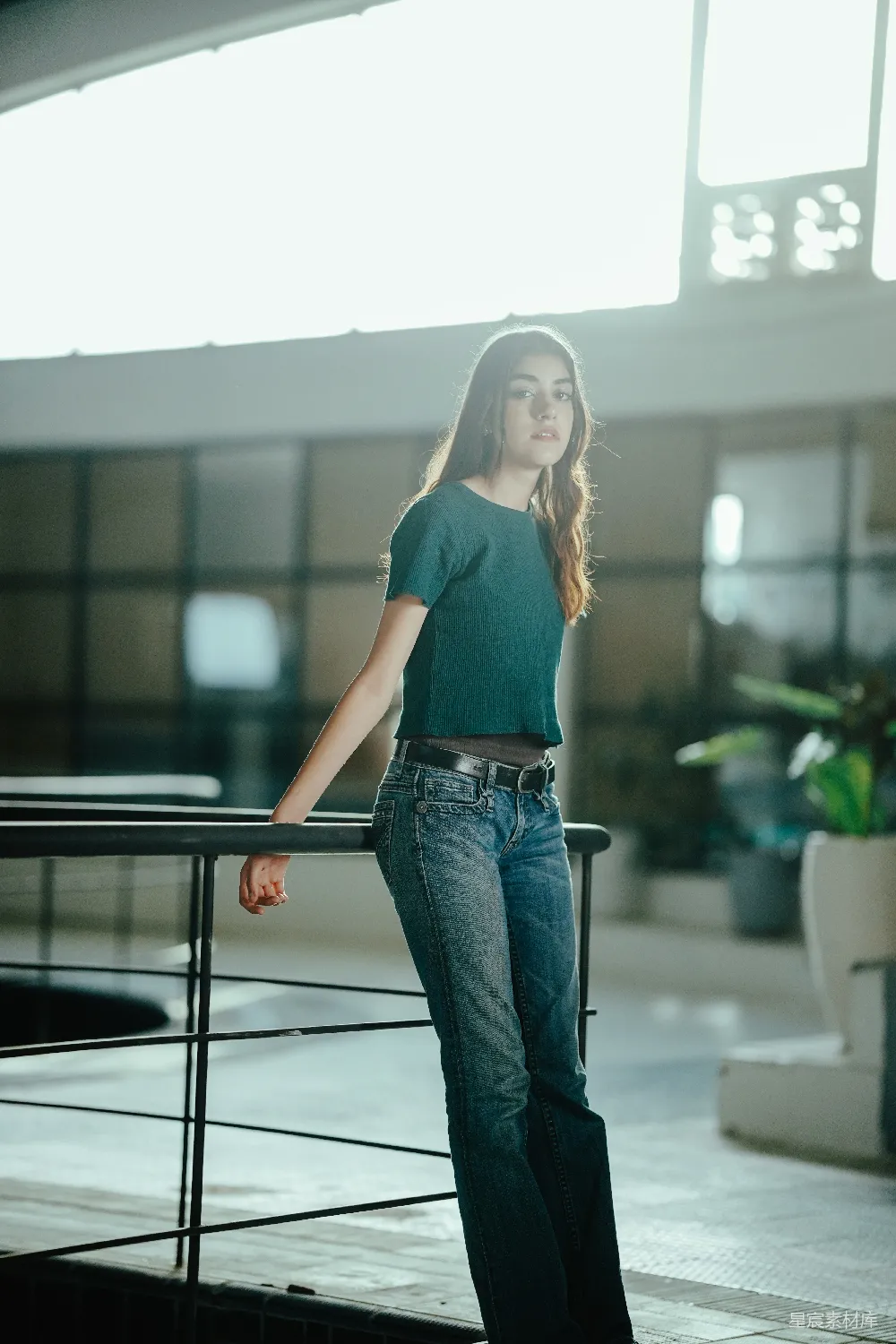 高清摄影  一位站在建筑物栏杆旁的女性。