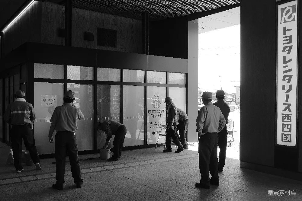 高清摄影  工人们站在一栋建筑外工作。