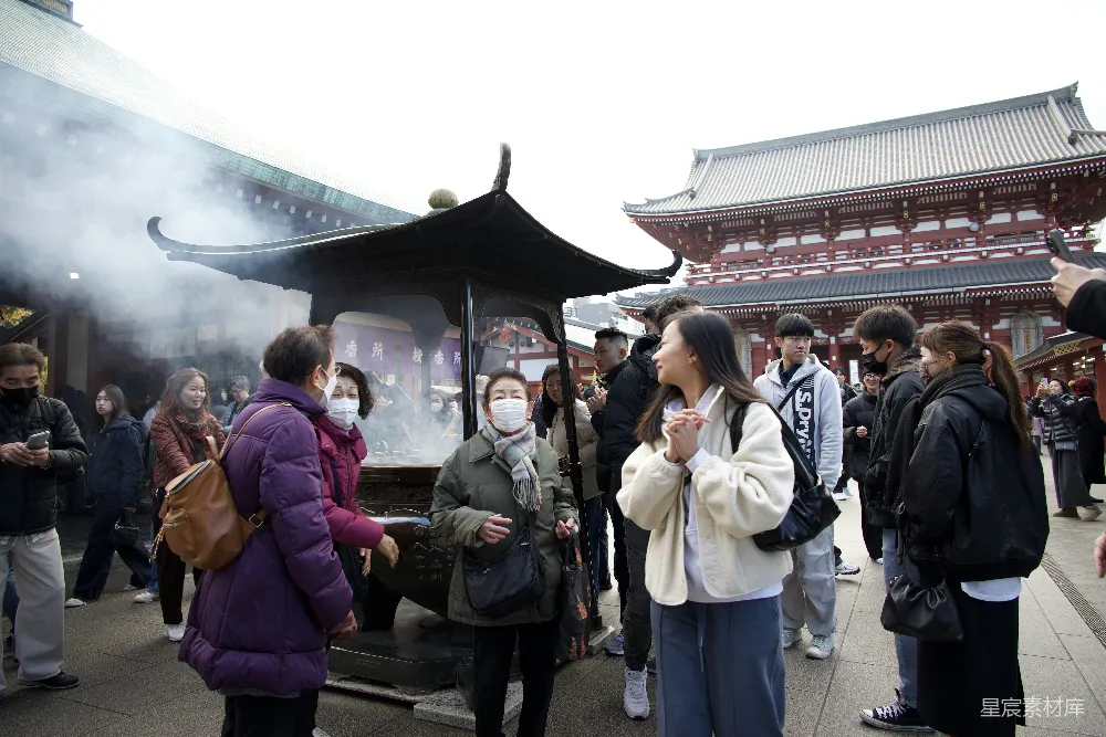高清摄影  人们聚集在寺庙附近，缭绕的香烟升起。