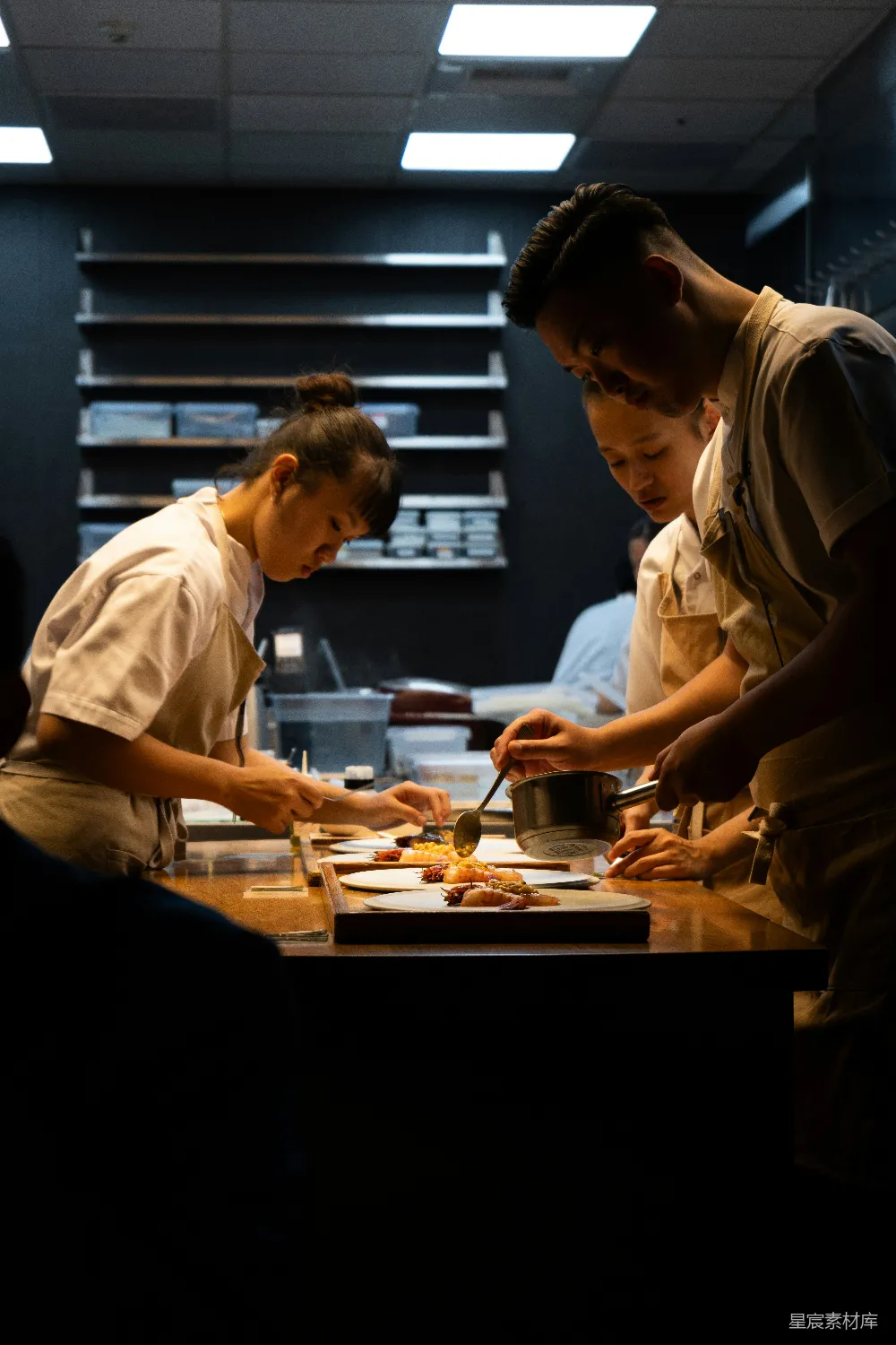 高清摄影  一群人围在厨房周围准备食物。