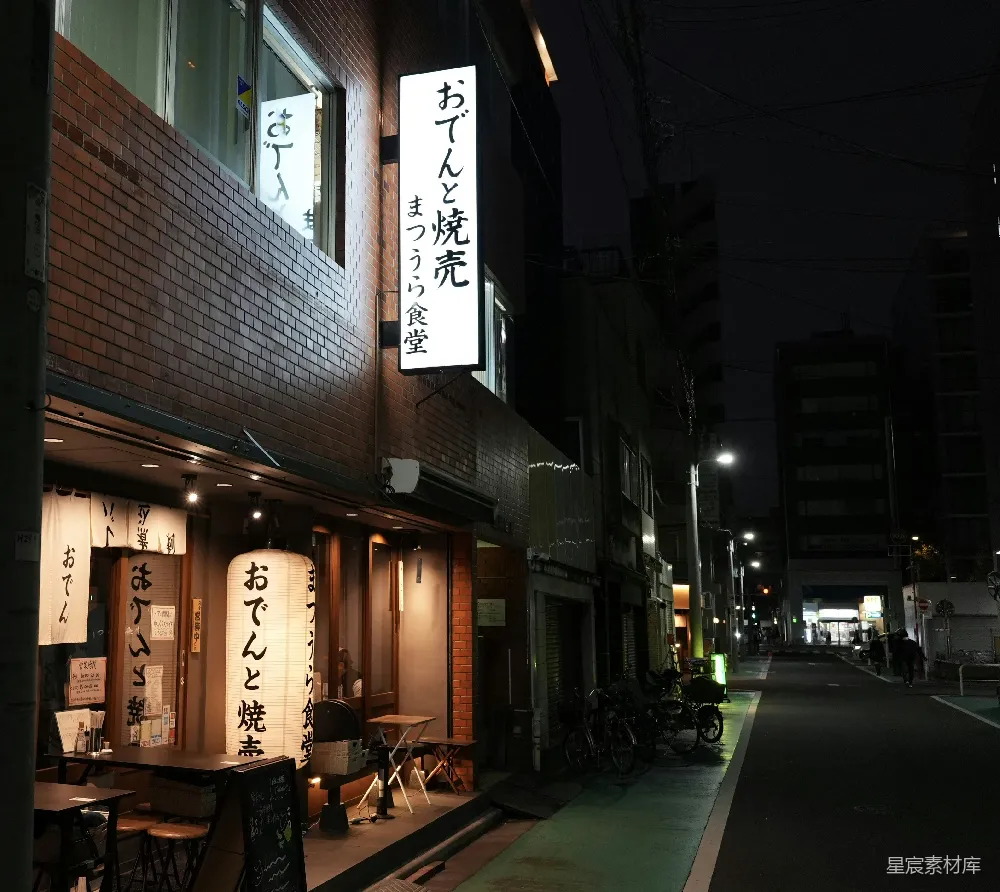 高清摄影  一条昏暗的街道，街道上有一栋建筑物，建筑物上有亚洲文字。