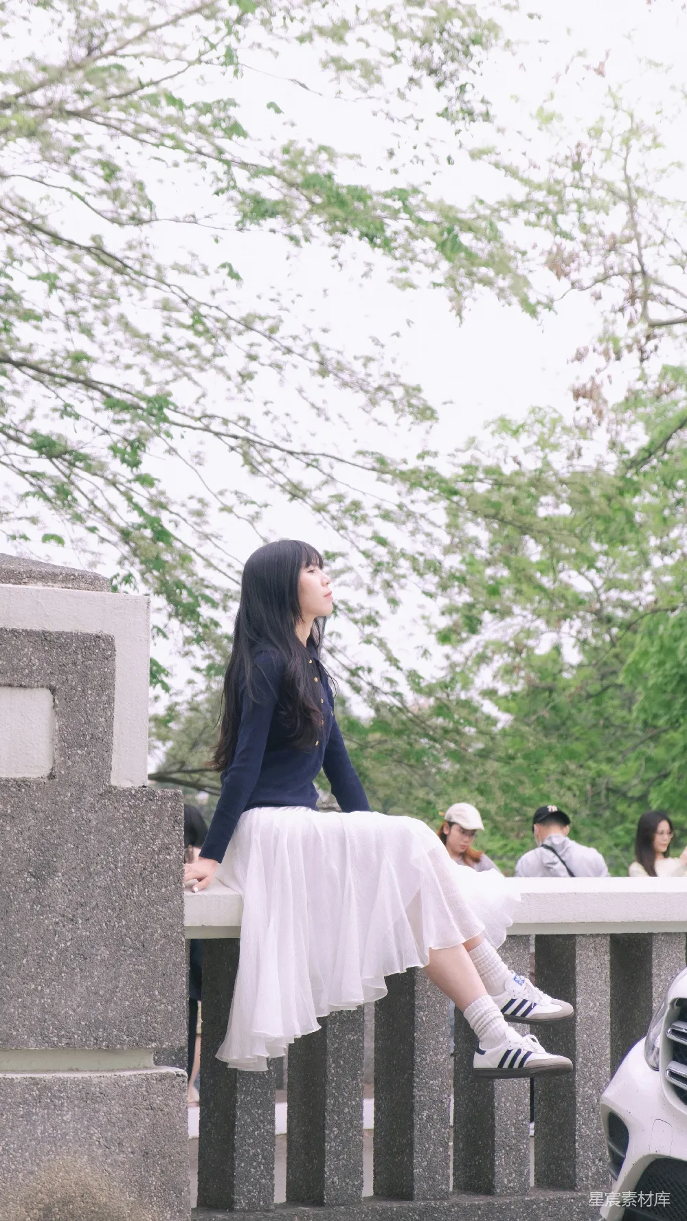 高清摄影  一位女士坐在石墙上。