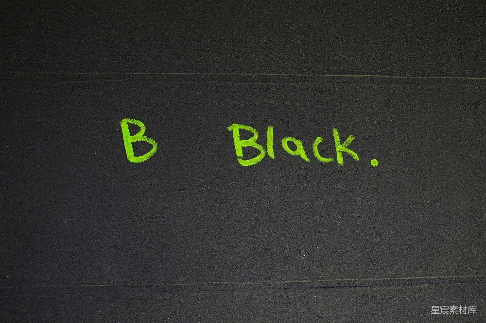 高清摄影  绿色字母拼写“b black.”在深色背景上。
