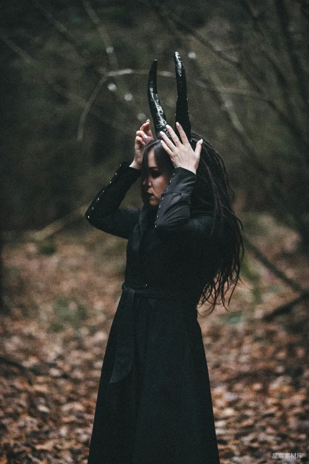 高清摄影  一个穿着黑色连衣裙的女人把双手举到头顶。