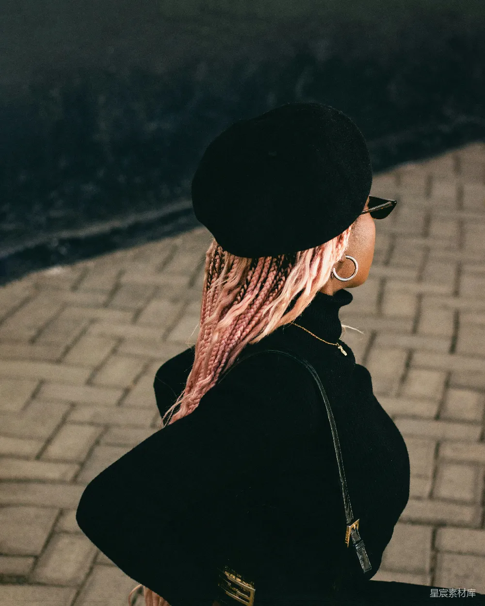 高清摄影  一个扎着粉色头发的女人在人行道上行走。