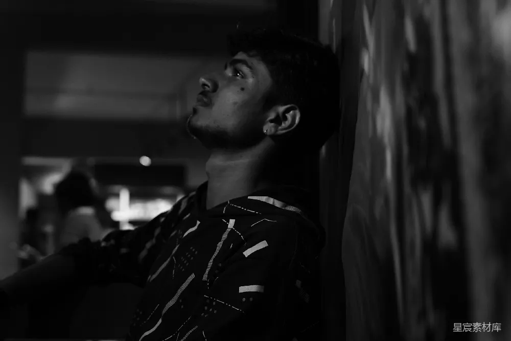 高清摄影  一个男人靠在墙上，抬头看。
