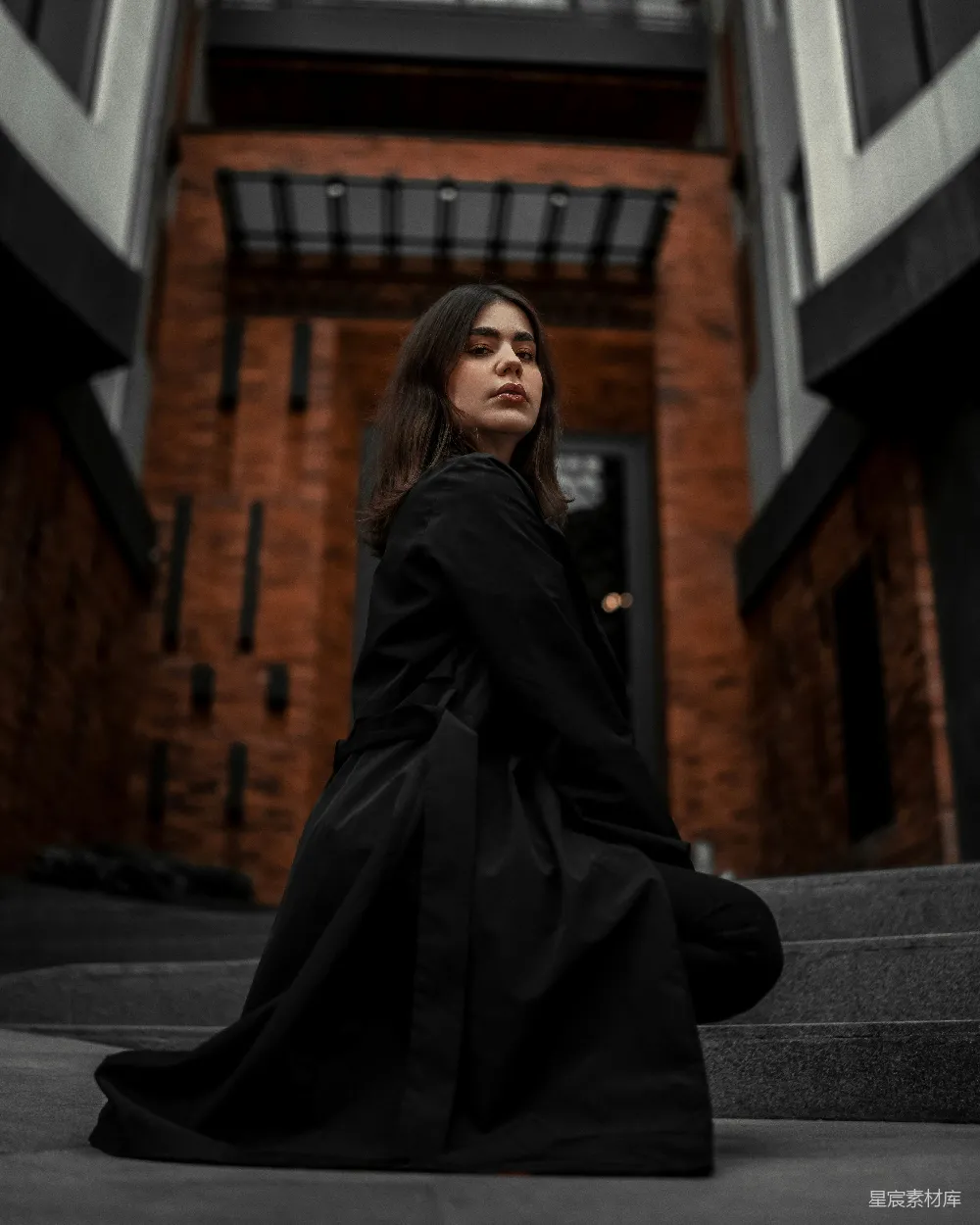 高清摄影  一位妇女坐在建筑物的台阶上。