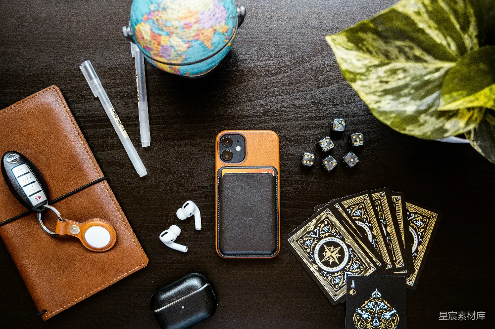 高清摄影  黑色和银色的iPhone壳放在棕色的木桌上