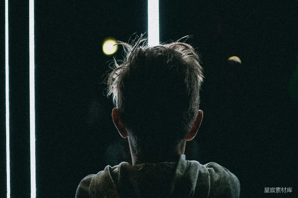 高清摄影  穿着灰色连帽衫的男人看着灯光。