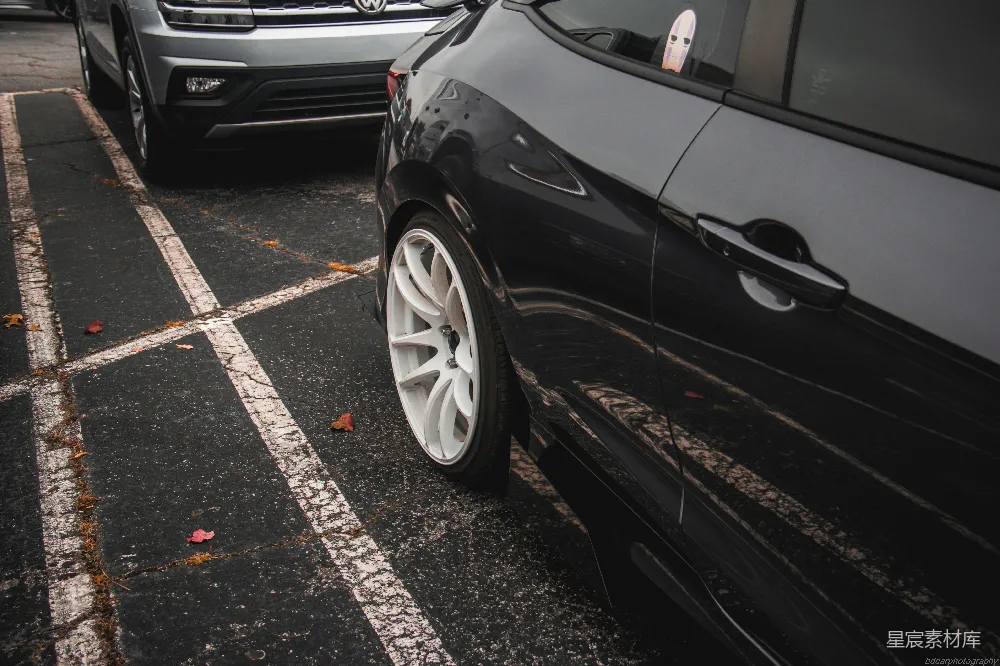 高清摄影  两辆汽车停在停车场里，挨着彼此。