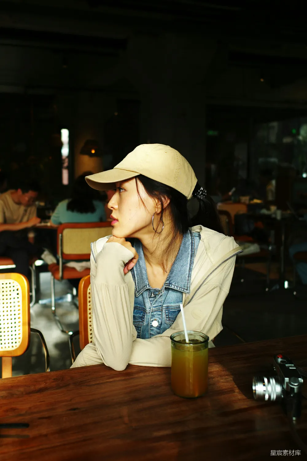 高清摄影 人物 一位女士坐在桌子旁，面前有一杯饮料。