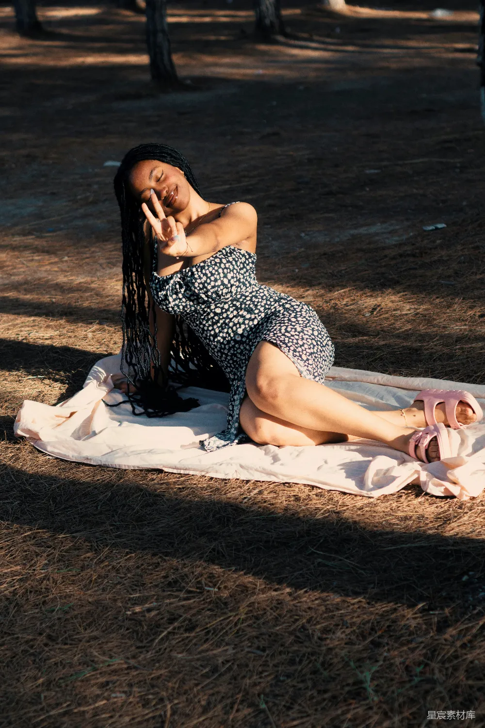 高清摄影  一个女人在森林的毯子上摆姿势拍照。