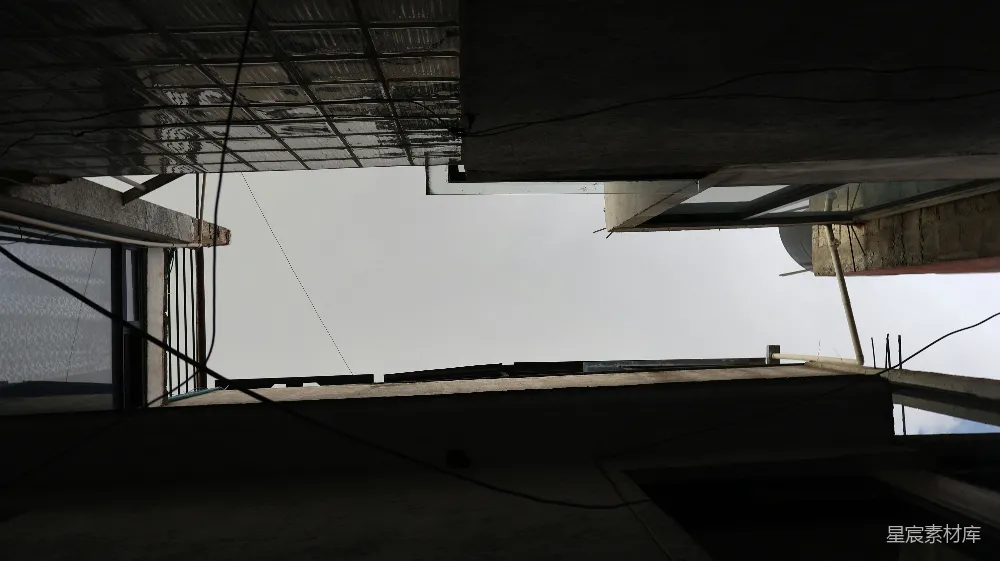 高清摄影  在黑暗、棱角分明的建筑物外立面之间可以看到天空。
