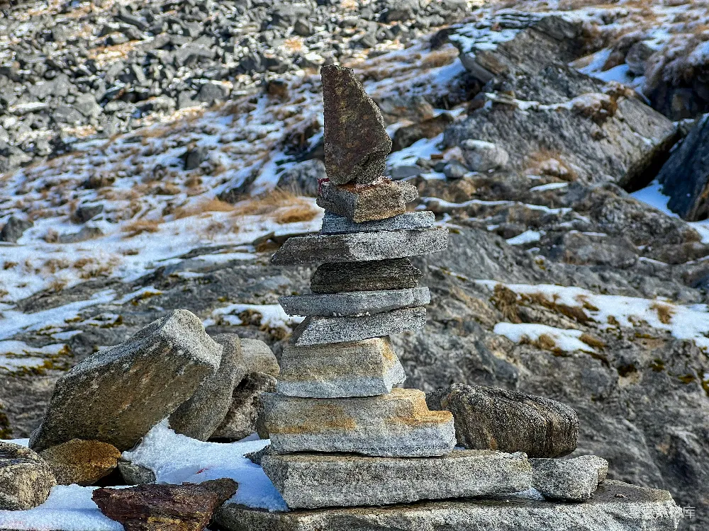 高清摄影  一堆石头堆在雪覆盖的地面上。