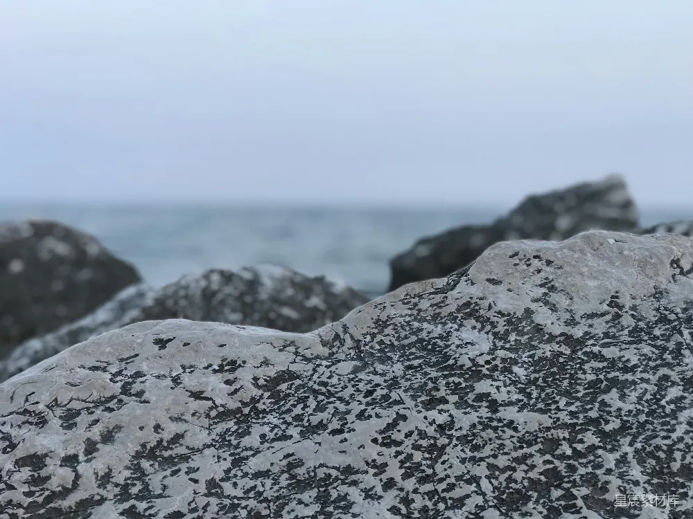 高清摄影  岩石的特写，背景中有一片水域。