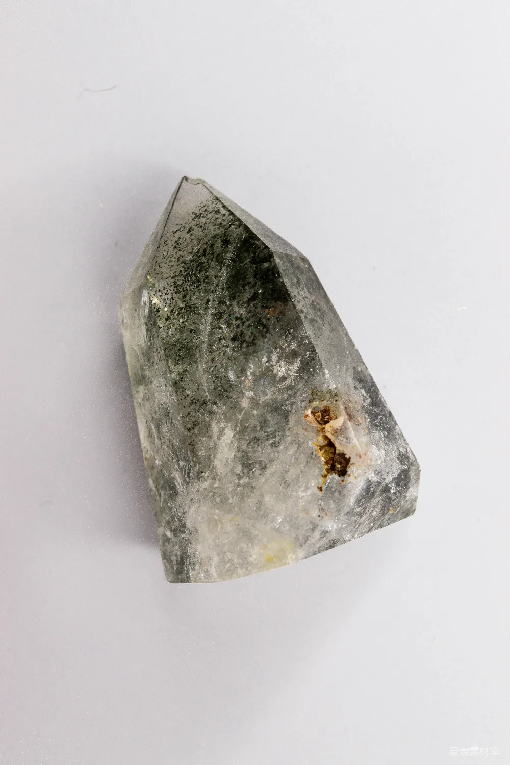 高清摄影  一颗清澈的水晶，其中含有绿色和棕色的杂质。