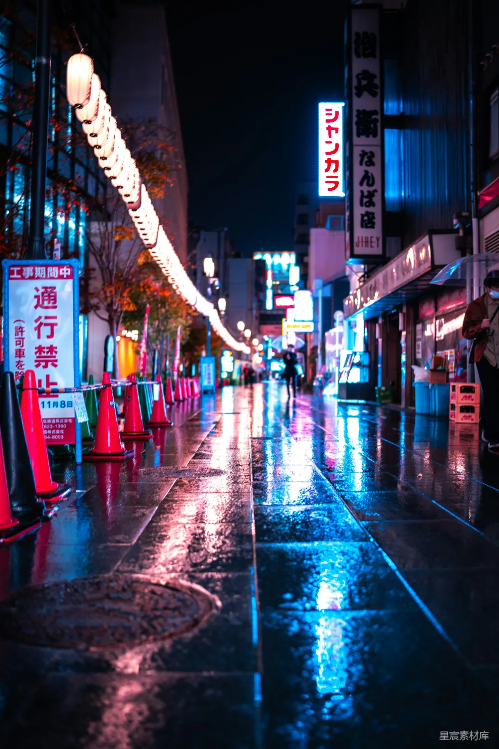 高清摄影 夜晚湿漉漉的城市街道上，有交通锥。