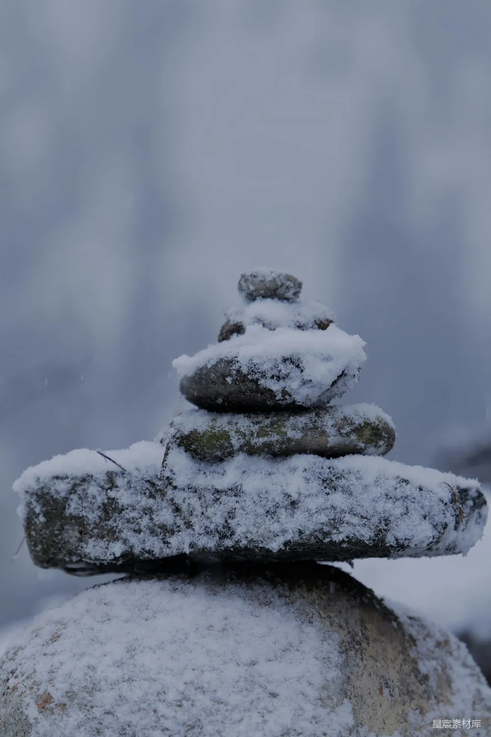 高清摄影  雪覆的岩石堆叠成一个平衡的金字塔。