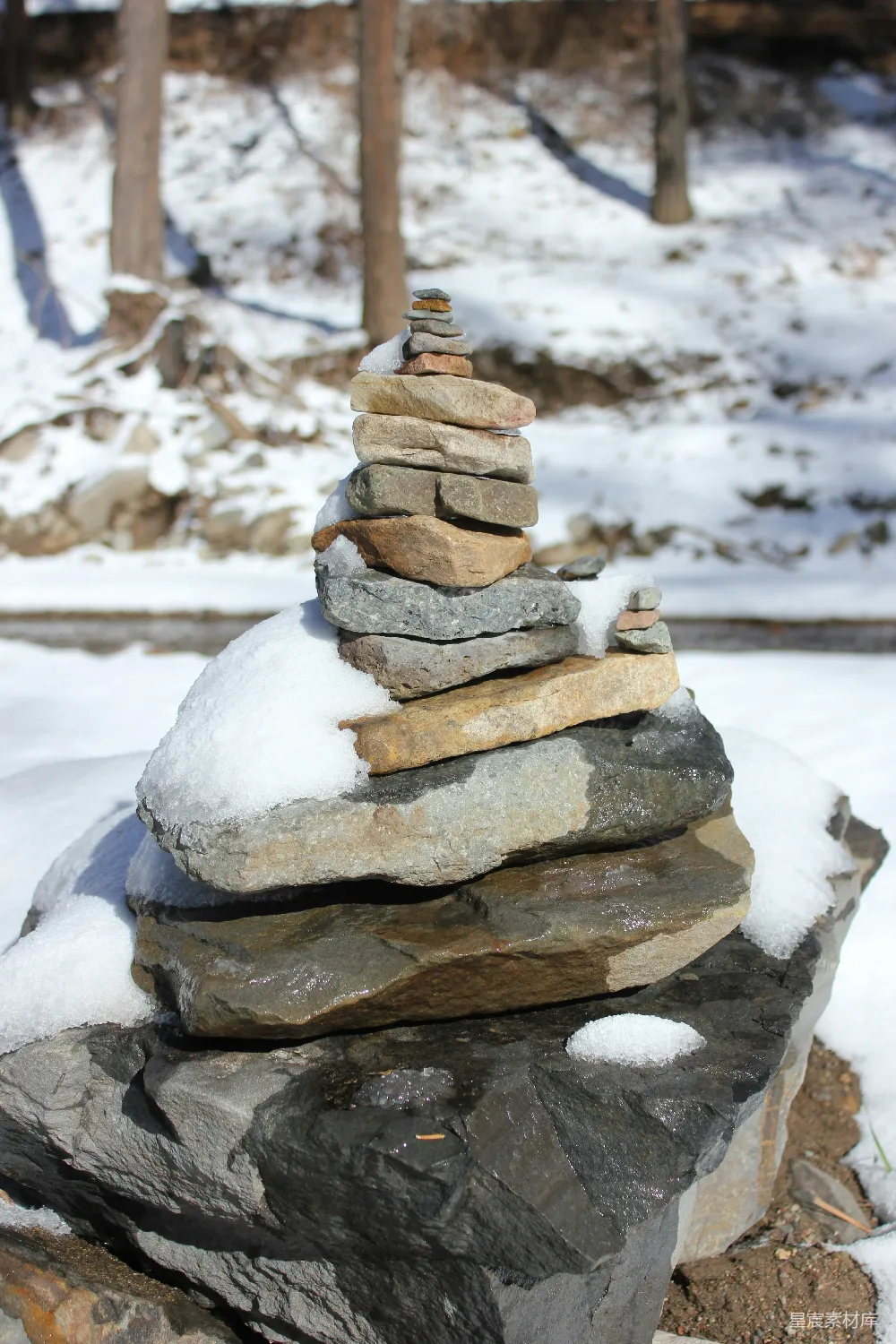 高清摄影  在雪地上平衡的石堆