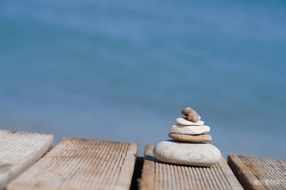 高清摄影  海边木板上的一堆平衡的石头。