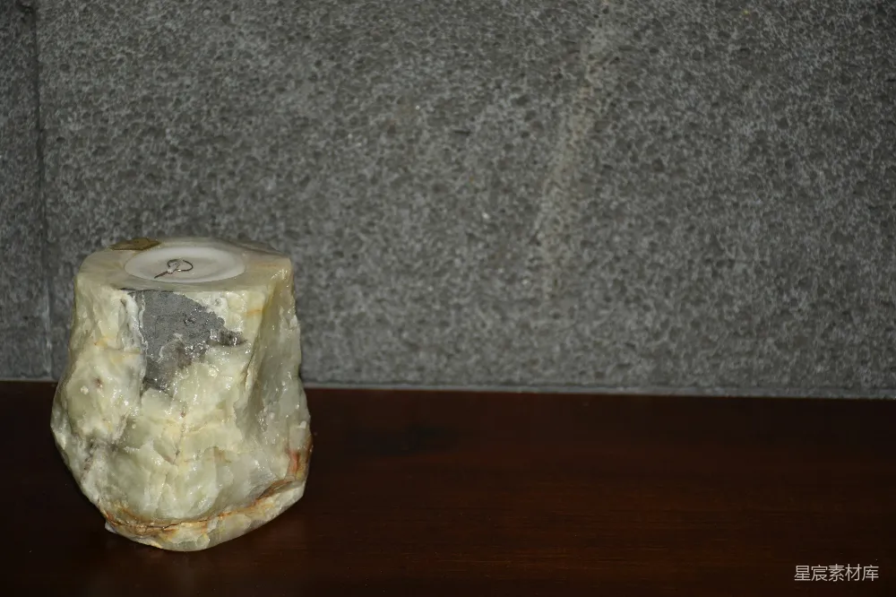 高清摄影  一块粗糙的浅色石头，放在深色的表面上。